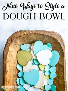 a wooden bowl filled with blue and white heart shaped cookies