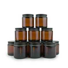 brown glass jars with black lids are stacked on top of each other in a pyramid