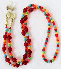 Red/Multicolor Beaded Eyeglass Chain 25.5" in length, made with glass beads, beading cord, metal lobster clasps, and adjustable rubber holders. Lobster clasps make it easy to change the rubber holders, and an extra pair of holders are included with every purchase. This Red/Multicolor Beaded Eyeglass Chain will ship to you in a gift box, securely mailed in a padded envelope. Shipping same or next day, thru USPS Ground Advantage, tracking and insurance included. Once mailed, you can track your pac Beading Cord, Eyeglass Chain, Colored Glass, Gift Box, Beaded Jewelry, Glass Beads, Chain, Beads, Red