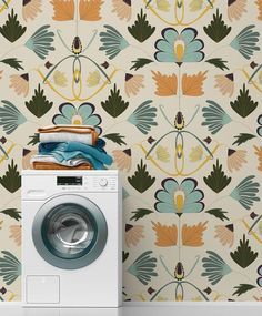 a washing machine sitting in front of a wallpaper