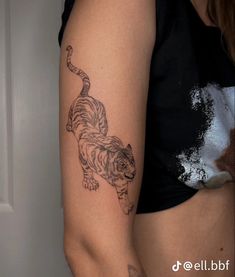 a woman's arm with a tiger tattoo on the left side of her body