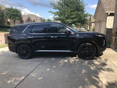 a black suv parked in front of a house