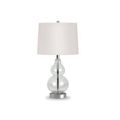 a table lamp with a white shade on it's side and a silver base