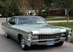 an old green car is parked on the street