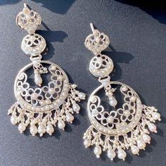 Featured are a pair of long chandbali earrings made on 925 sterling silver and embellished with freshwater pearls. The earrings close with a bombay screw. Luxury White Chandbalis For Women, Luxury Silver Chandbali Jewelry, Luxury Chandbali Danglers With Pearl Drop, Luxury Silver Chandbalis For Formal Occasions, Luxury Silver Chandbali Jhumkas, Luxury Bridal Chandbali Earrings With Pearl Drop, Luxury Silver Chandbali Diamond Earrings, Luxury Silver Round Chandbalis, Luxury White Chandbali Jhumkas