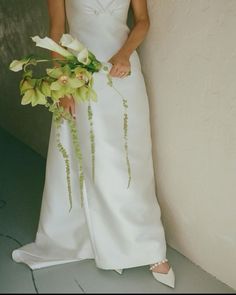 a woman in a white dress holding a bouquet