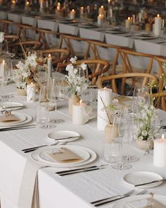 a long table is set with place settings and candles