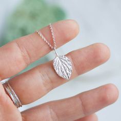 "This delicate necklace features tiny fine silver leaf with beautiful and realistic details. The leaf is textured from both sides and looks gorgeous alone or layered! I sculpted the leaf from silver metal clay and then fired it to become fine silver. The leaf pendant is about 15mm (5/8\"). You can buy it with or without dainty sterling silver chain. If you are buying it as a gift I would suggest 16\" (40cm) or 18\" (45cm) chain. If you are not sure about the length, place a string around your ne Silver Leaf Necklace, Silver Leaf-shaped Nature-inspired Necklace, Handmade Sterling Silver Leaf-shaped Necklace, Handmade Sterling Silver Leaf Necklace, Minimalist Leaf-shaped Sterling Silver Jewelry, Minimalist Sterling Silver Leaf Jewelry, Nature-inspired Sterling Silver Leaf Necklace, Nature-inspired Leaf Shaped Sterling Silver Necklace, Silver Leaf-shaped Sterling Silver Necklace