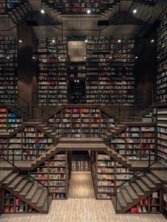 the interior of a library with many bookshelves and stairs leading up to them