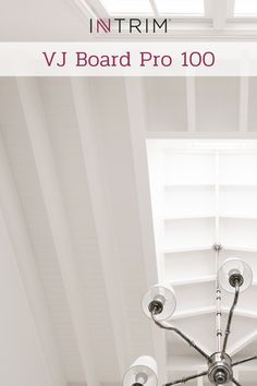 a chandelier hanging from the ceiling in a room with white walls and windows