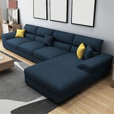 a large blue couch sitting on top of a hard wood floor next to a wooden table