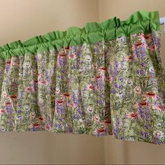 the curtain is hanging in front of the window with flowers and butterflies on it's valance