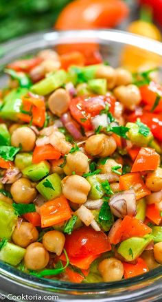 a glass bowl filled with chickpeas, carrots and cucumber salad