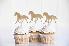 three cupcakes with gold glitter horses on top