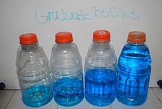 three large water bottles are lined up next to each other on the floor, and one is blue with orange caps