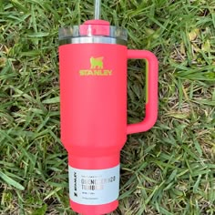 a red travel mug sitting in the grass