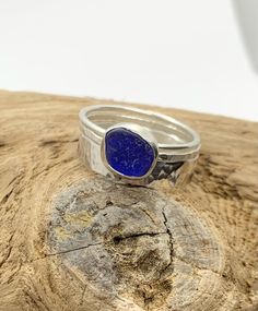 Handmade sterling silver ring featuring a tiny dark cobalt blue sea glass nugget from the west coast of Scotland hand set in a fine silver bezel setting on a slim textured sterling silver ring.  UK size N    Other similar items available: Pendants https://rocklobstersea glass.etsy.com?section_id=24274610 Rings  https://rocklobstersea glass.etsy.com?section_id=22382744 Bracelets & bangles  https://rocklobstersea glass.etsy.com?section_id=24286591 Earrings  https://rocklobstersea glass.etsy.com?section_id=22910663 Sterling Silver Stackable Jewelry For Jewelry Making, Blue Sterling Silver Stackable Jewelry, Minimalist Stackable Blue Jewelry, Stackable Sterling Silver Jewelry For Gifts, Stackable Sterling Silver Jewelry Gift, Sterling Silver Stackable Jewelry As Gift, Stackable Sterling Silver Jewelry As A Gift, Minimalist Sapphire Sterling Silver Jewelry, Minimalist Blue Stackable Jewelry