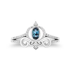 a white gold ring with an oval blue topazte and diamond accents on the band