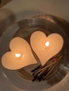 two candles in the shape of hearts on a plate