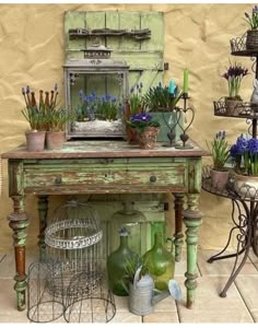 an old table with flowers and plants on it