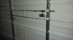 two fishing rods hanging from the side of a garage door