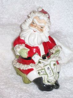 a santa clause figurine sitting on top of a white blanket