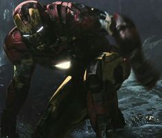 iron man standing in the water with his hands on his chest and glowing from behind