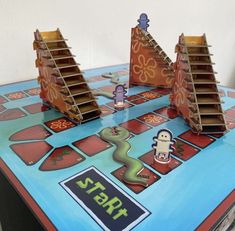 a close up of a board game on a table with paper cut out of it