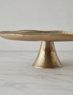 a gold cake plate sitting on top of a white counter