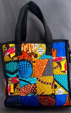 Authentic Tanzanian Africanprint handbag handmade by Tanzanian Maasai Women with a patchwork of traditional Kitenge material 100% cotton - Length: 36 Centimetres  - Width: 39 Centimetre - Depth: 18 Centimetre - Material: Kitenge fabric  This handbag is very fashionable, super lightweight and very spacious with an extra pocket inside.  Can be used as every day bag, working/study bag (fits laptops and books), carry on bag in the flight, day to the beach (fits several towels) or on your day out. Ch Kitenge Bags, Multicolor Patchwork Tote Bag, Black Square Bag With Patchwork, Black Square Bags With Patchwork, Square Black Bags With Patchwork, Black Square Patchwork Bags, Multicolor Quilted Shoulder Bag For Daily Use, Multicolor Cotton Patchwork Bags, Traditional Multicolor Cotton Shoulder Bag