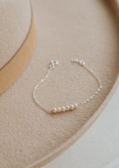 The bracelet version of our Pearl Linked Necklace. Let each of these pearls symbolize something special in your life. Use it as a daily reminder to count your blessing. 2-7 pearls are attached to our dainty cable chain. Bracelet is adjustable from 6.5 - 7". Available in 14kt Gold Fill + Sterling Silver. Layered with our Birdie Initial Bracelet. Handmade in Eau Claire, WI. Our jewelry is handmade so each piece will be unique and may vary slightly from what is pictured.