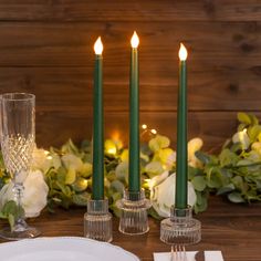 the table is set with candles, plates and silverware