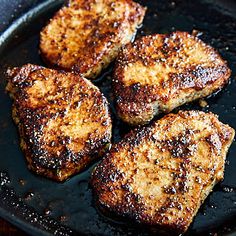 four pieces of meat cooking in a skillet