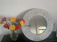 a vase filled with flowers sitting next to a mirror