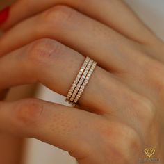 a woman's hand with a ring on it and three rows of diamonds in the middle