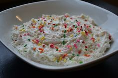 a white bowl filled with sprinkles on top of a table