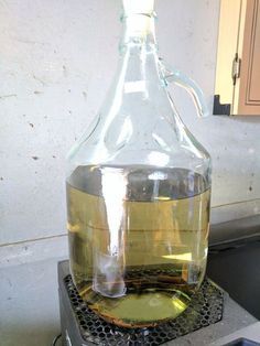 a large glass bottle filled with liquid sitting on top of a stove