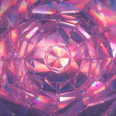 a close up view of an intricately colored diamond in pink and purple tones with iridescent hues