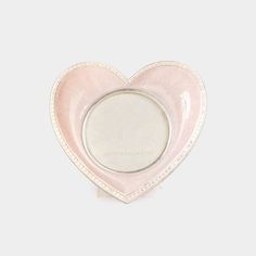 a pink heart shaped dish on a white background