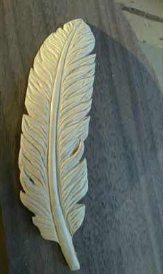 a close up of a white feather on a table