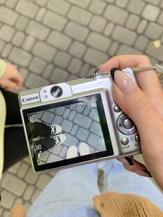 a person is holding a camera and taking a picture with their cell phone while sitting on the ground