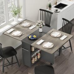 a kitchen table with chairs and plates on it