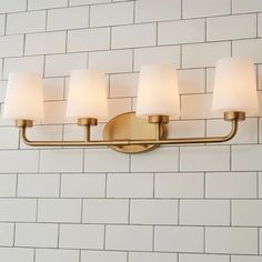 a bathroom light that is on the wall with white bricks in the backround