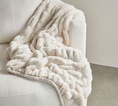 a white couch with a blanket on it