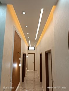 an empty hallway with lights on the ceiling