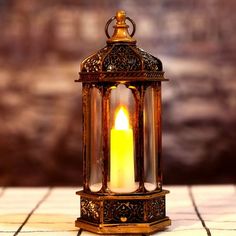 a lit candle sitting on top of a tiled floor