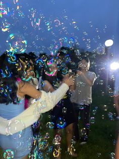 a group of people are blowing bubbles in the air while one person takes a photo