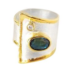 Yianni Creations Midas Collection 100% Handmade Artisan Gorgeous Ring from Fine Silver with an overlay of 24 Karat Yellow Gold features 1.60 Carat London Blue Topaz accompanied by 0.03 Carat Diamond complemented by unique techniques of craftsmanship - brushed texture and nature-inspired liquid edges. The core of this beautiful geometrical shaped ring is made from Fine Silver 950 purity, which is plated with Palladium, to protect the ring from the elements. The Gold rims are created by 24 Karat Y Jewelry 2024, Month Gemstones, Micro Pave Ring, 24 Karat Gold, Modernist Jewelry, Gorgeous Ring, Artisan Rings, Contemporary Ring, Gold And Silver Rings