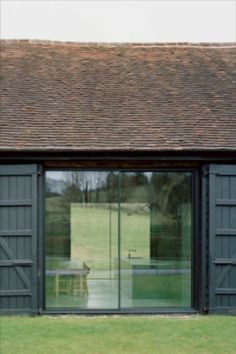 Glass sliding barn doors with timber shutters Converted Buildings, Organic Scandinavian, Black Cladding, Barn Door Window, Eco Cabin