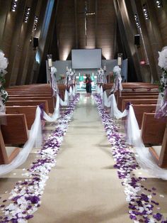 the aisle is decorated with purple and white flowers